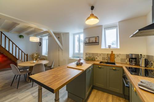 une cuisine avec des placards verts et une table en bois dans l'établissement Le logis d'Anahy, à Blois