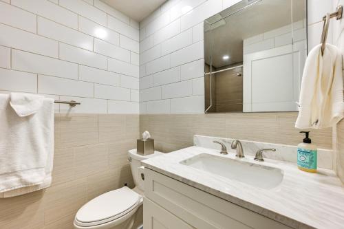 a bathroom with a toilet and a sink and a mirror at 2 Mi to State Fair Puyallup Home with Private Yard! in Puyallup