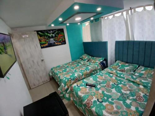 a bedroom with two beds and a tv in it at Edificio Tocore Rodadero in Gaira