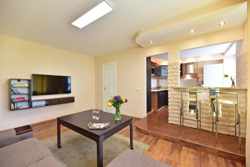 een woonkamer met een bank en een tafel bij Oksanos Apartamentai Druskininku centre in Druskininkai