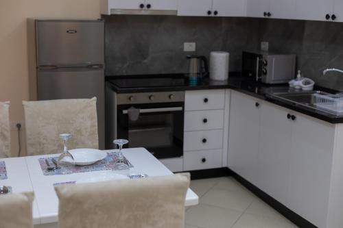 a kitchen with a table and a stove top oven at Vila Emi Apartment's in Durrës