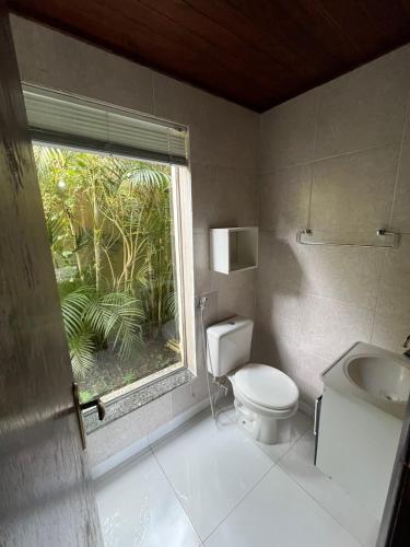 a bathroom with a toilet and a window at Recanto dos Vianas in Teresópolis