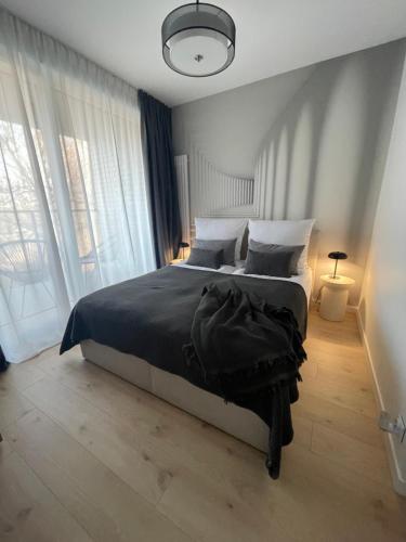 Un dormitorio con una cama y una ventana grande. en Apartamenty Wawrzyńca Goplana parking, en Poznan
