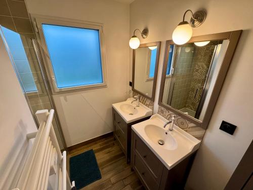 a bathroom with two sinks and a large mirror at Villa Napoléni - Maison - Calme - Jardin - Parking in La Roche-sur-Yon