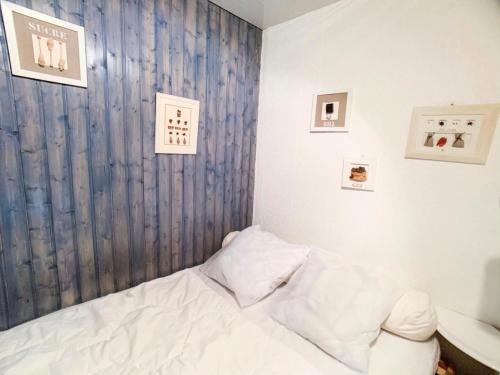- une chambre avec un lit blanc et des photos sur le mur dans l'établissement Résidence Grandes Platieres 2 - Studio cabine situé dans le centre du Val Claret MAE-2324, à Tignes
