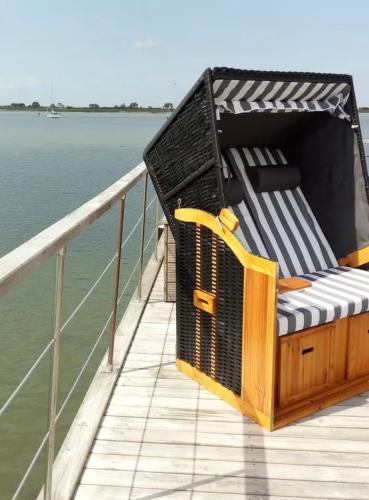 a chair sitting on the deck of a boat at Sealodge II Huus & Meer in Ortmühle