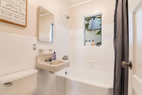 a white bathroom with a sink and a toilet and a window at Second-Floor 1-BR Near Beverly Hills and Top Los Angeles Attractions in Los Angeles