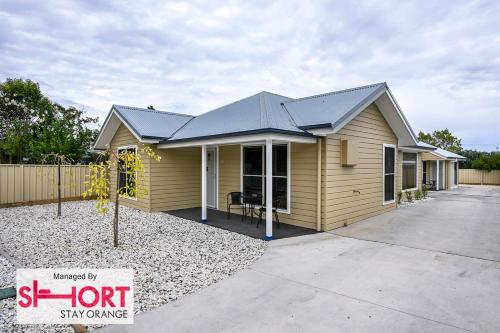 a small yellow house with a black roof at Wolaroi Villa 1, with Netflix and Disney Plus in Orange