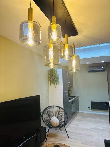 a living room with several lights hanging from the ceiling at Élégant appartement avec bain balnéothérapie in Liège