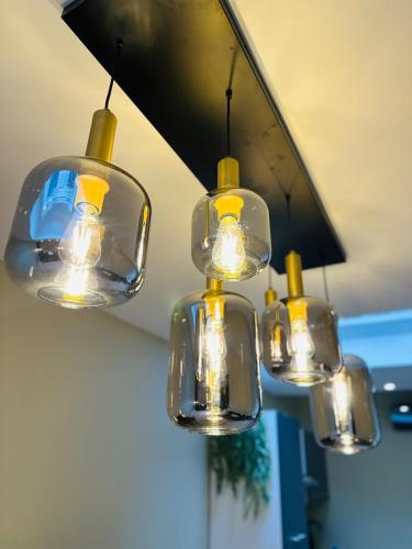 a group of four lights hanging from a ceiling at Élégant appartement avec bain balnéothérapie in Liège