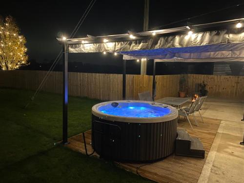 a hot tub in a backyard at night with lights at Rose barn hot tub holidays in the Cotswolds in Badsey