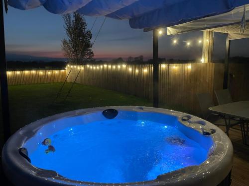 a hot tub in a backyard at night at Rose barn hot tub holidays in the Cotswolds in Badsey