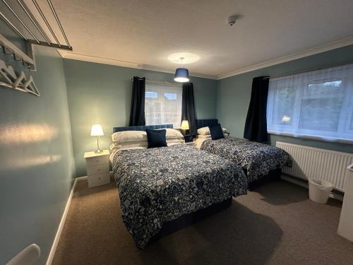 a bedroom with two beds and a window at Lynn Hill Guest House in East Dereham