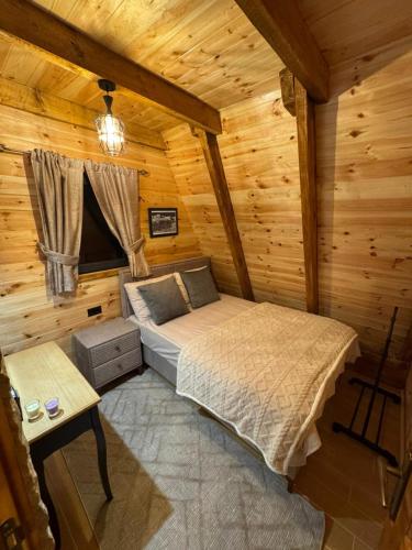 a bedroom with a bed in a log cabin at Villas Sunny Hill in Žabljak