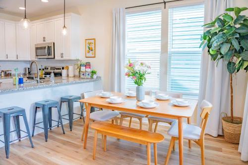 a kitchen and dining room with a wooden table and chairs at The Royal Crane Suite Newly Built Upscale Central in Gainesville