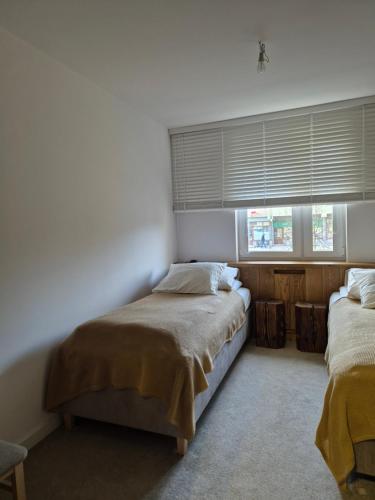 a bedroom with two beds and a window with blinds at Apartament Słoneczna in Gorlice
