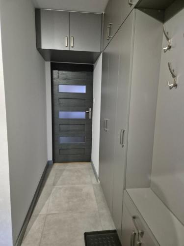 a walk in closet with white cabinets and a door at Apartament Słoneczna in Gorlice