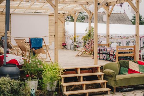 une terrasse avec une pergola en bois, un canapé et des chaises dans l'établissement Stodoła Pogódki, à Pogódki