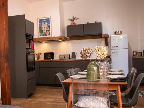 une cuisine avec une table avec des chaises et un réfrigérateur dans l'établissement Maison Rémoise Hyper Centre - Parking - Terrace, à Reims