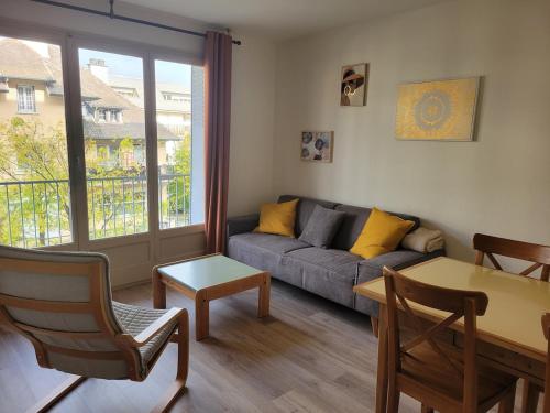 un salon avec un canapé et une table dans l'établissement Les Vallées, à Thonon-les-Bains