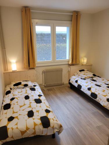 deux lits dans une chambre avec deux fenêtres dans l'établissement Les Vallées, à Thonon-les-Bains