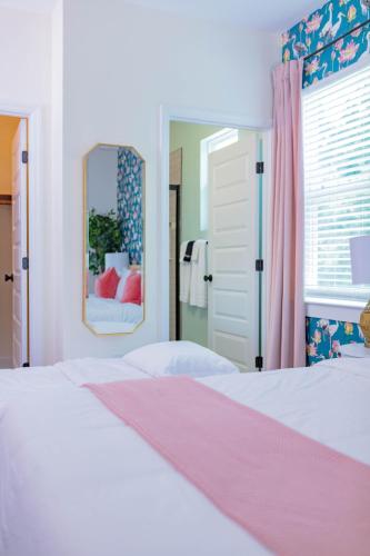 a bedroom with a white bed and a mirror at The Lotus Suite Newly Built Upscale Central in Gainesville