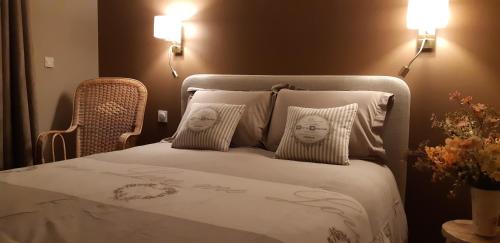 a bedroom with a bed with two faces on the pillows at La Villanelle maison d'hôtes in Pelousey