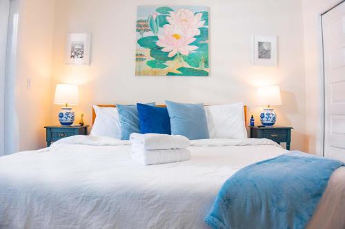 a bedroom with a large white bed with two lamps at The Lotus Suite Newly Built Upscale Central in Gainesville