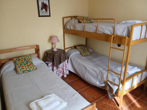 a room with two bunk beds and a table with a lamp at Cabañas don fortuno in Puerto Deseado