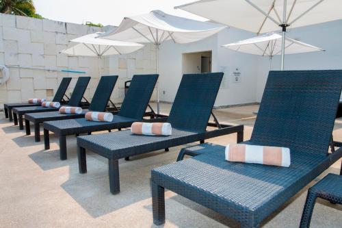 a row of blue chairs and umbrellas on a patio at Holiday Inn Acapulco La Isla by IHG in Acapulco