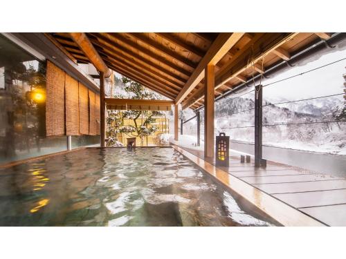 a pool of water in a building with windows at Togen Kurobe UnazukiOnsen - Vacation STAY 04362v in Kurobe