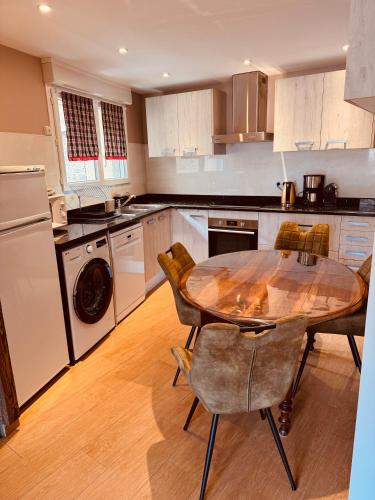 une cuisine avec une table en bois, des chaises et une table, ainsi qu'une salle à manger dans l'établissement Les Fermes de Cal Panche Le Petit Relais, aux Angles