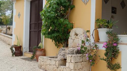 a building with potted plants on the side of it at Villa Leonardo in Canicattini Bagni