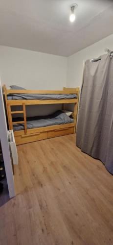 Cette chambre comprend 2 lits superposés et du parquet. dans l'établissement Grand studio montagnard, à Mieussy