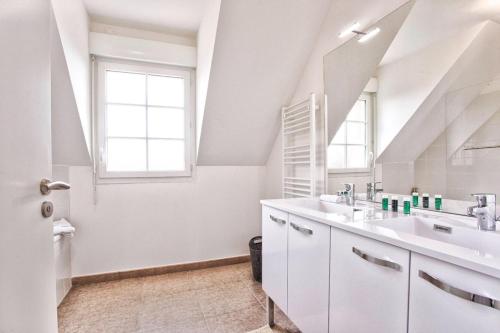 une salle de bain blanche avec deux lavabos et une fenêtre dans l'établissement Villa Kdo 4 chambres CLS Deauville, à Deauville