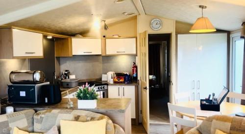 a kitchen and living room with a table in a room at Skiddaw Lodges- The Lake District in Plumbland