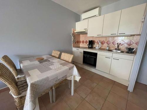 une cuisine avec une table et des chaises dans une pièce dans l'établissement Appartement 2 pièces cabine, proche plage et commerces, climatisation - FR-1-328-273, à La Grande Motte