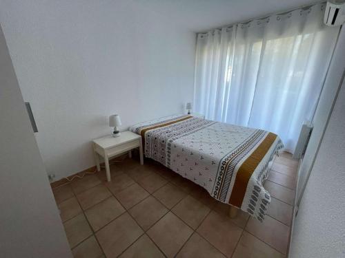 une chambre avec un lit, une table et une fenêtre dans l'établissement Appartement 2 pièces cabine, proche plage et commerces, climatisation - FR-1-328-273, à La Grande Motte