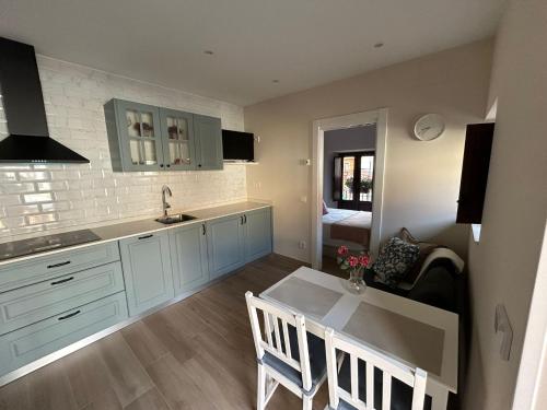 ラス・アレーナス・デ・カブラレスにあるApartamentos San Roqueの青いキャビネットとテーブルと椅子のあるキッチン