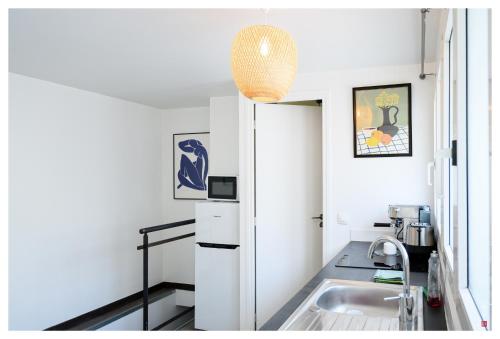 une petite cuisine avec un évier et un réfrigérateur dans l'établissement 2 pièces à 10 minutes de Paris, à Ivry-sur-Seine