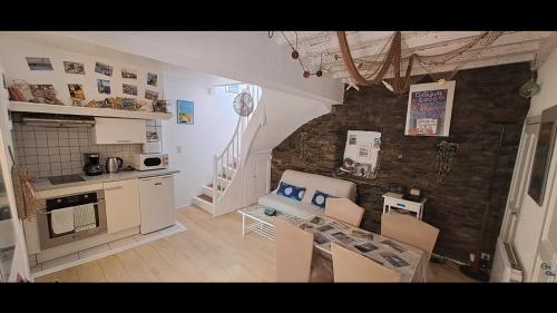 une cuisine avec une table et des chaises et un mur en pierre dans l'établissement Jetez l'ancre dans notre maison de pêcheur !, à Collioure