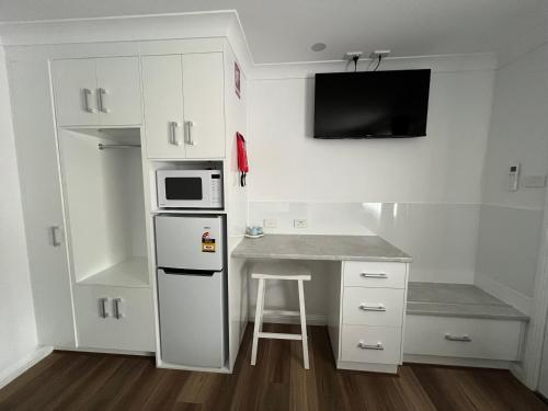a small kitchen with a counter and a microwave at Almond Inn Motel in Tamworth