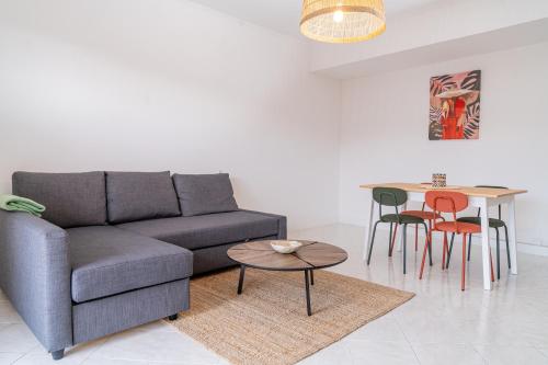 un salon avec un canapé, une table et des chaises dans l'établissement 2 pièces - 4 personnes - Entièrement équipé et idéalement situé proche toutes commodités, à Menton