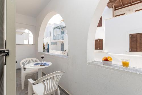 a small table and chairs in a room with an archway at Azur Playa Naxos in Naxos Chora