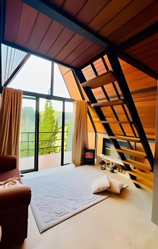 a large room with a bed and large windows at Pousada Casa Florinda in Teresópolis