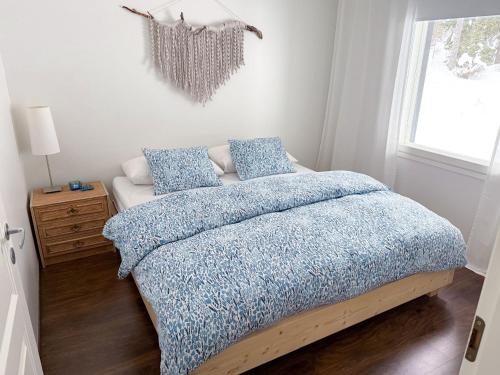 una camera da letto con un letto con una coperta blu e una finestra di Arctic Hideout a Rovaniemi
