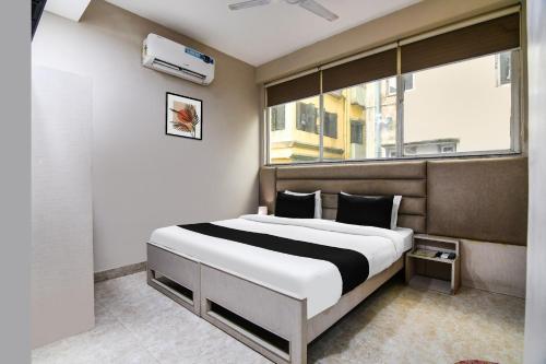 a bedroom with a large bed and a window at Super Collection O Ruby Formerly Hiland International in Kolkata