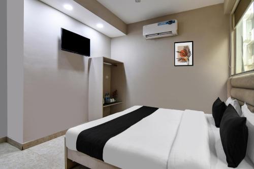 a bedroom with a bed and a flat screen tv at Super Collection O Ruby Formerly Hiland International in Kolkata