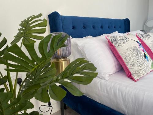 a blue bed with a pillow and a plant at Iconic Location 3 Bed 2 Bath Flat near Regents Park in London