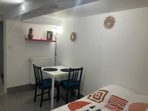 a bedroom with a table and two chairs and a bed at Petite Chambre avec SdB partagée in Angers